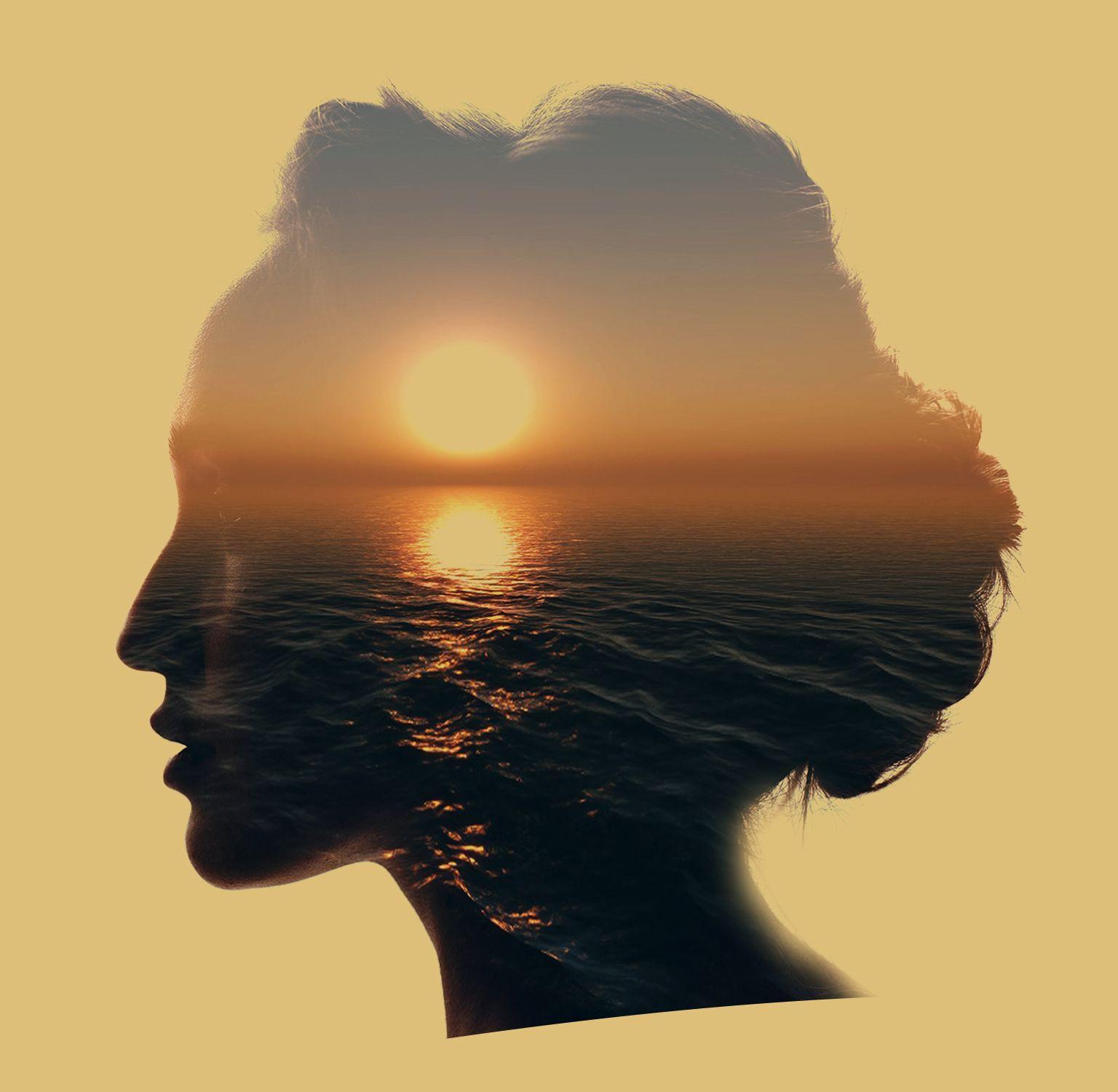 Silhouette of a woman's profile overlaid with a serene sunset over the ocean.